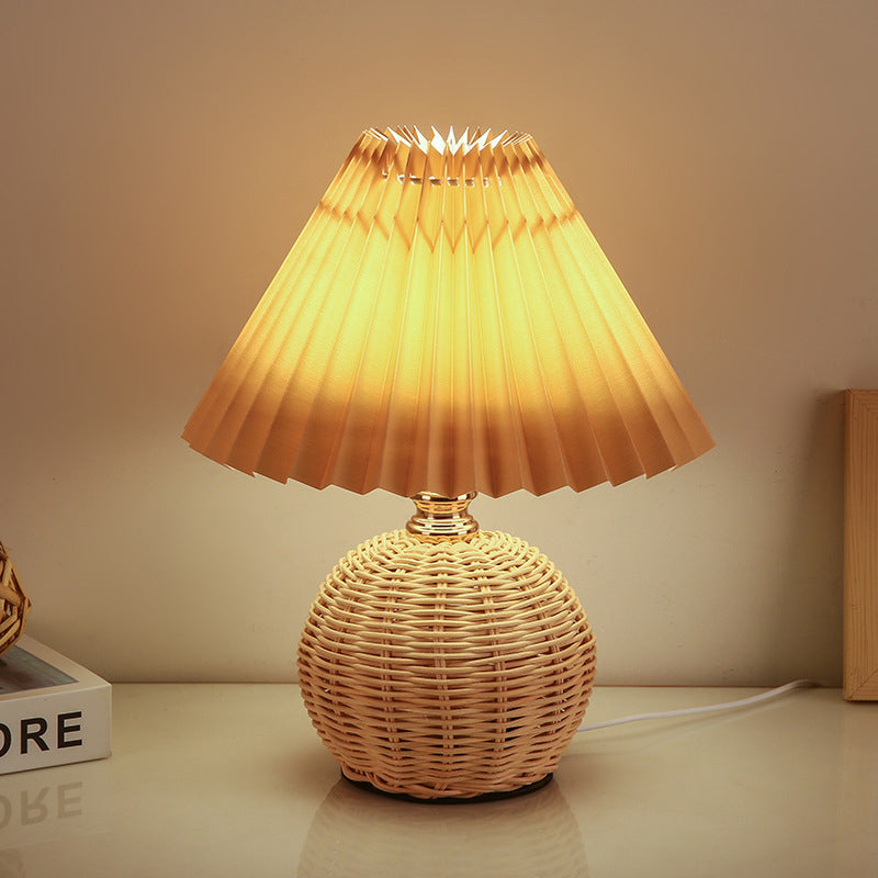 Contemporary Nordic Rattan Pleated LED Table Lamp for Bedroom 

Enhance your bedroom decor with this stylish contemporary Nordic rattan fabric table lamp. Featuring a unique pleated conic design, this LED lamp offers a warm, inviting glow while showcasing