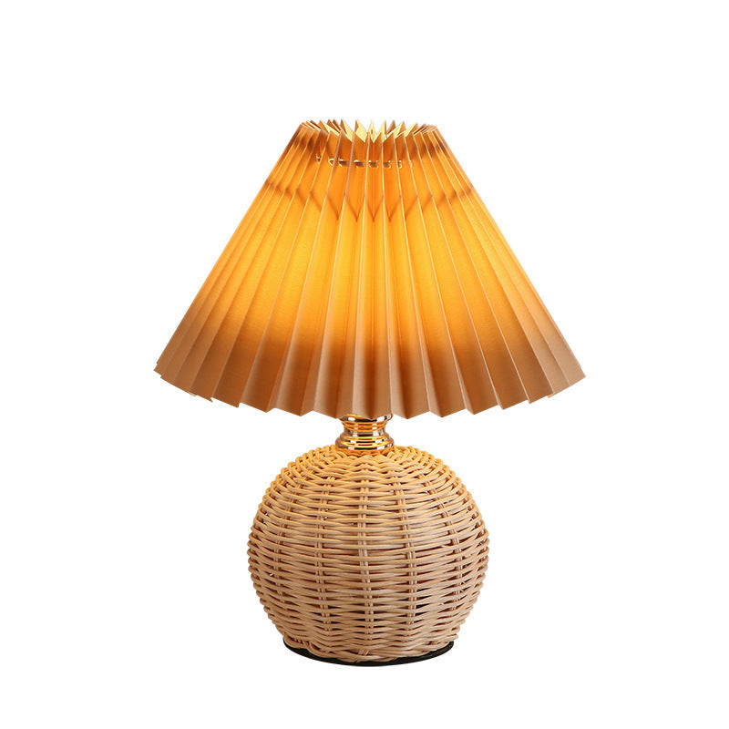Contemporary Nordic Rattan Pleated LED Table Lamp for Bedroom 

Enhance your bedroom decor with this stylish contemporary Nordic rattan fabric table lamp. Featuring a unique pleated conic design, this LED lamp offers a warm, inviting glow while showcasing