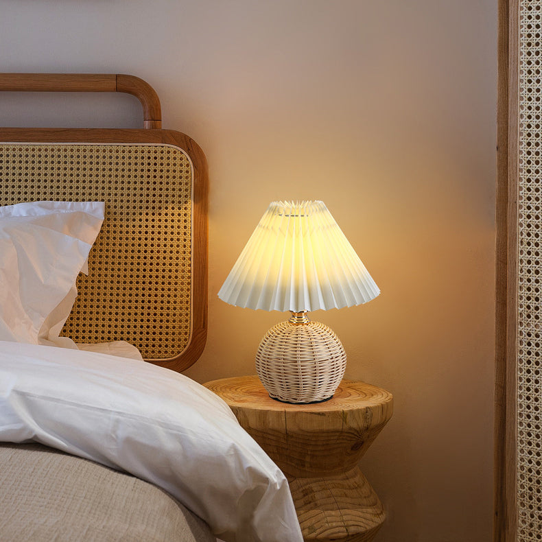 Contemporary Nordic Rattan Pleated LED Table Lamp for Bedroom 

Enhance your bedroom decor with this stylish contemporary Nordic rattan fabric table lamp. Featuring a unique pleated conic design, this LED lamp offers a warm, inviting glow while showcasing