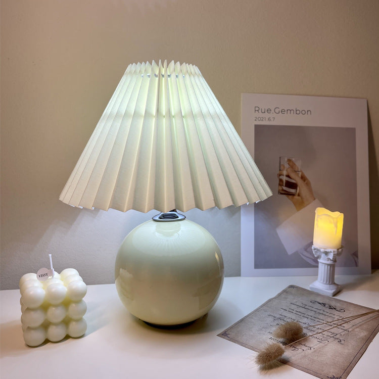 Modern Minimalist Round Fabric Pleated Ceramic 1-Light Table Lamp for Bedroom | Stylish Bedside Lighting | Contemporary Home Decor | Elegant Bedroom Accent | Soft Ambient Illumination | Decorative Lighting Fixture | Chic Fabric Shade | Ceramic Base Design