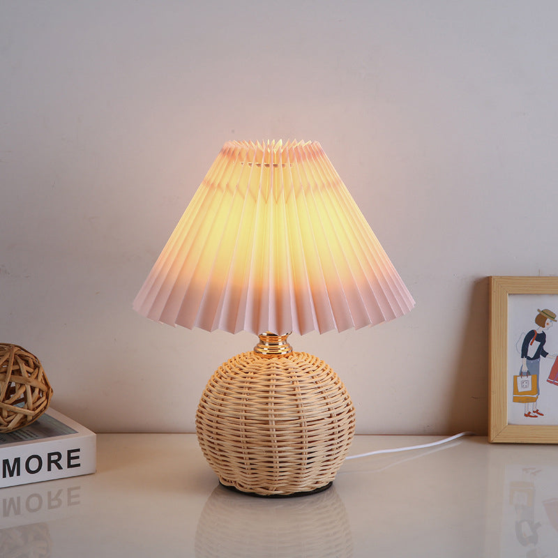 Contemporary Nordic Rattan Pleated LED Table Lamp for Bedroom 

Enhance your bedroom decor with this stylish contemporary Nordic rattan fabric table lamp. Featuring a unique pleated conic design, this LED lamp offers a warm, inviting glow while showcasing