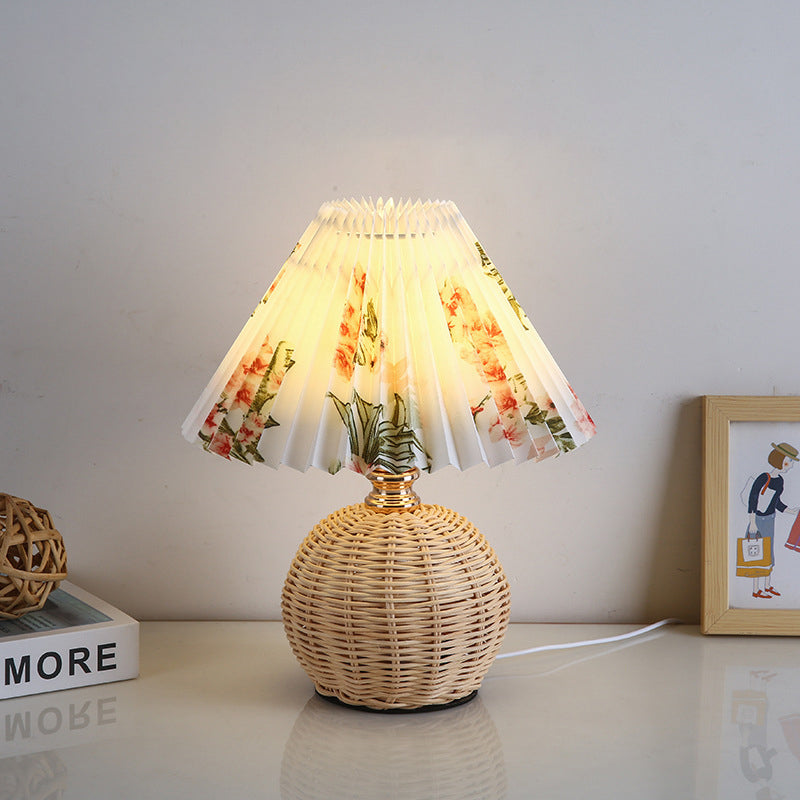 Contemporary Nordic Rattan Pleated LED Table Lamp for Bedroom 

Enhance your bedroom decor with this stylish contemporary Nordic rattan fabric table lamp. Featuring a unique pleated conic design, this LED lamp offers a warm, inviting glow while showcasing