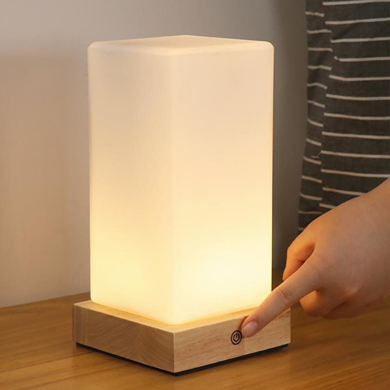Title: Battery-Powered LED Wooden Cube Lamp

Description: Illuminate your space with our stylish Square Table Light. This Battery-Powered LED Wooden Cube Lamp combines modern design with warm ambiance, making it perfect for any room. Ideal for nightstands